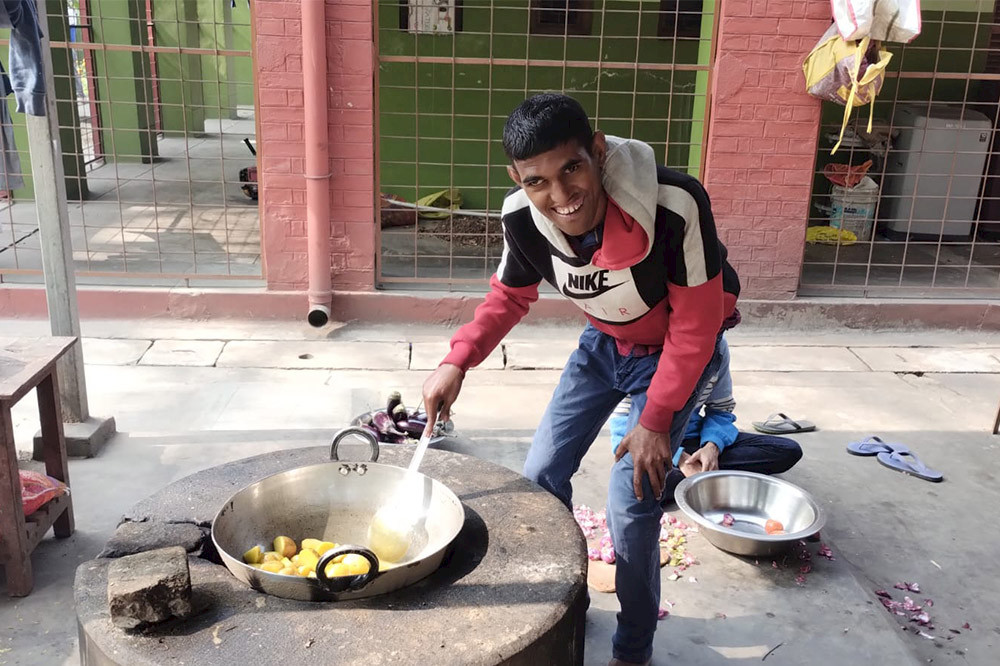 Bild zeigt eine Person beim Kochen auf der Straße.