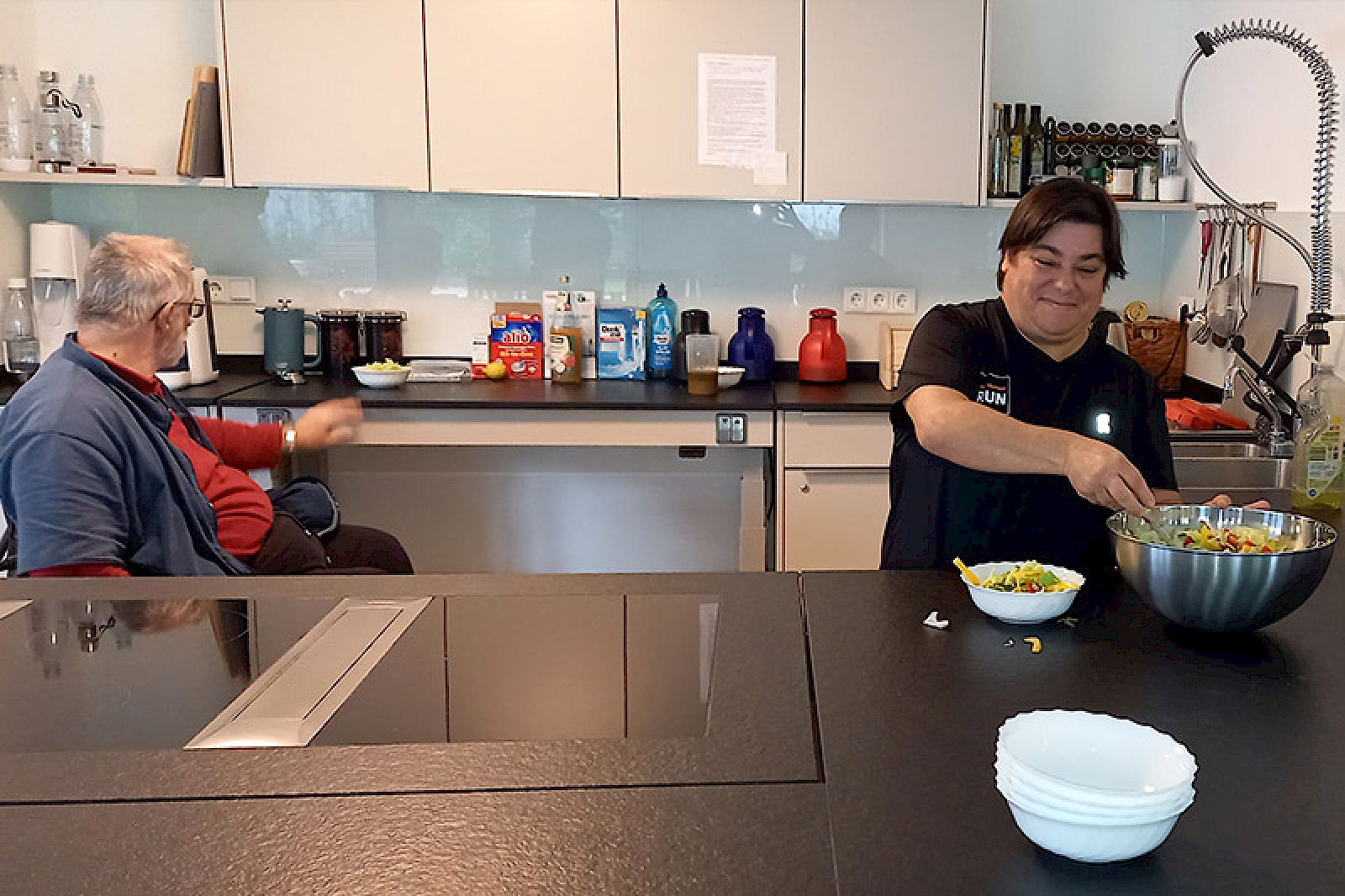 Bild zeigt zwei Personen in einer modernen Küche.