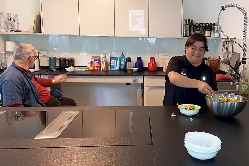 Bild zeigt zwei Personen in einer modernen Küche.